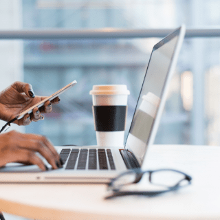 desk with laptop, phone, and coffee