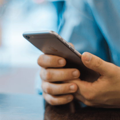 man in blue shirt using phone