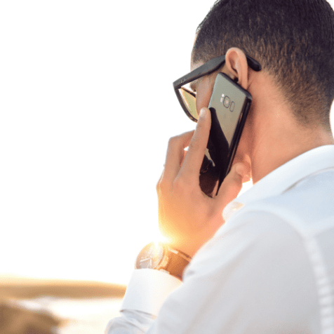 man in white shirt talking on phone