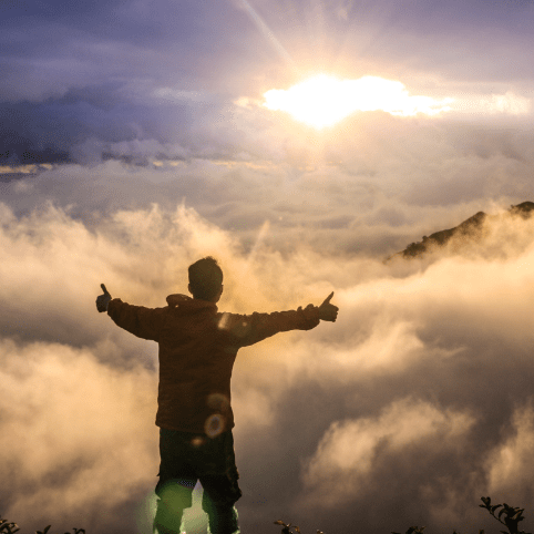 person posing thumbs up in fog at sunrise