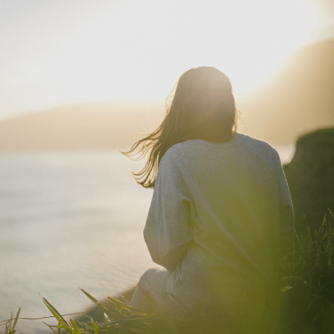 woman with back turned overlooking water